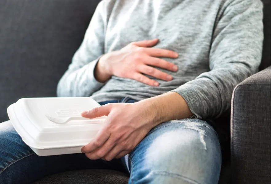 homme avec livraison de nourriture tenant son ventre