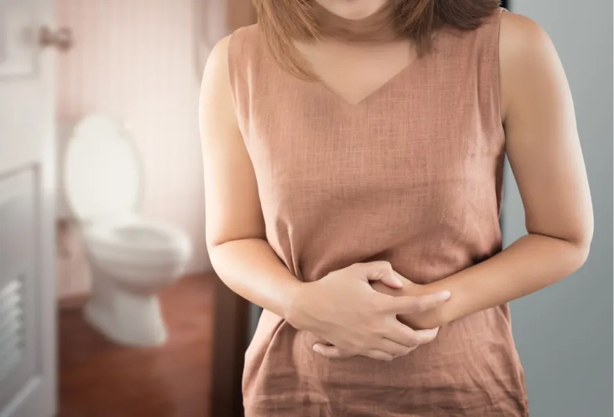 femme tenant son ventre avec un bain derrière