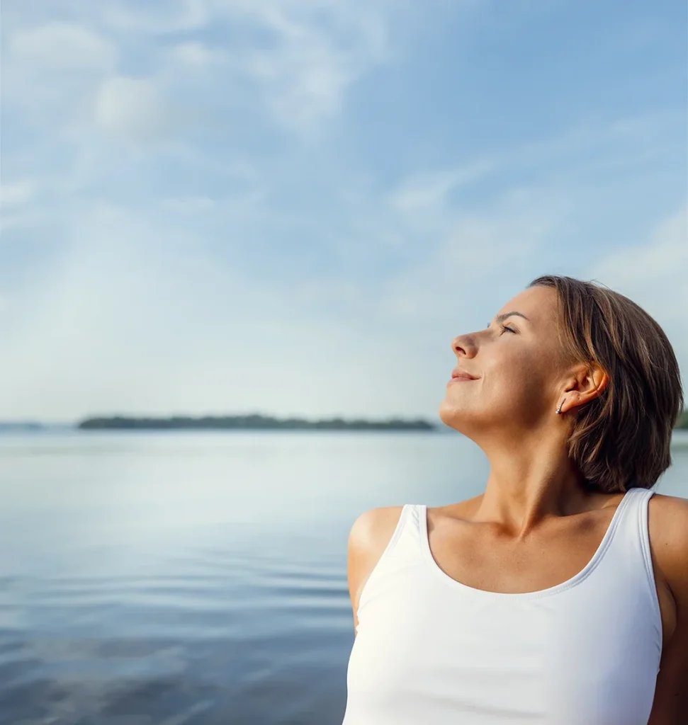 femme au bord d’un lac regardant le ciel