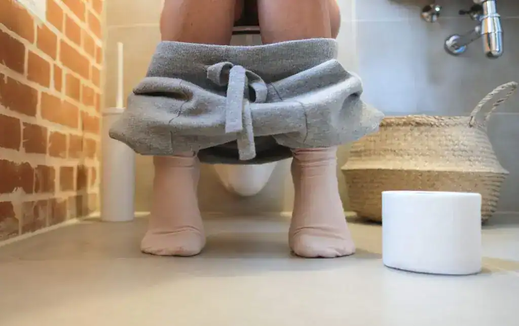 Personne assise aux toilettes, représentation de la diarrhée