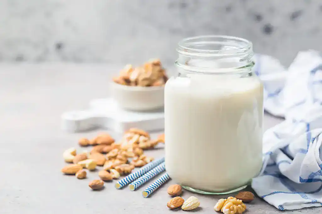 Lait végétal aux amandes dans un pot de verre avec amandes et noix
